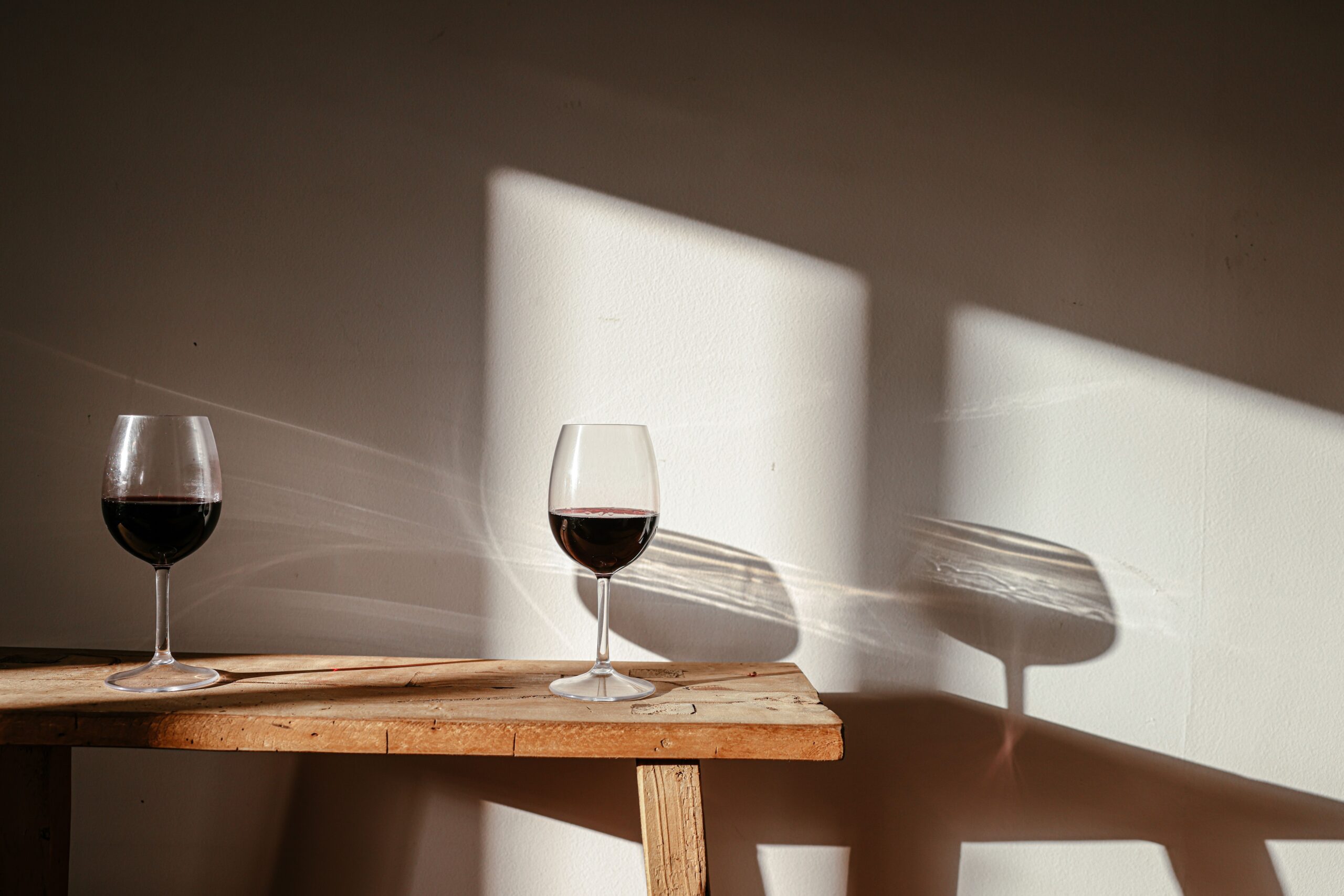 Duas taças de vinho numa mesa com luz quente