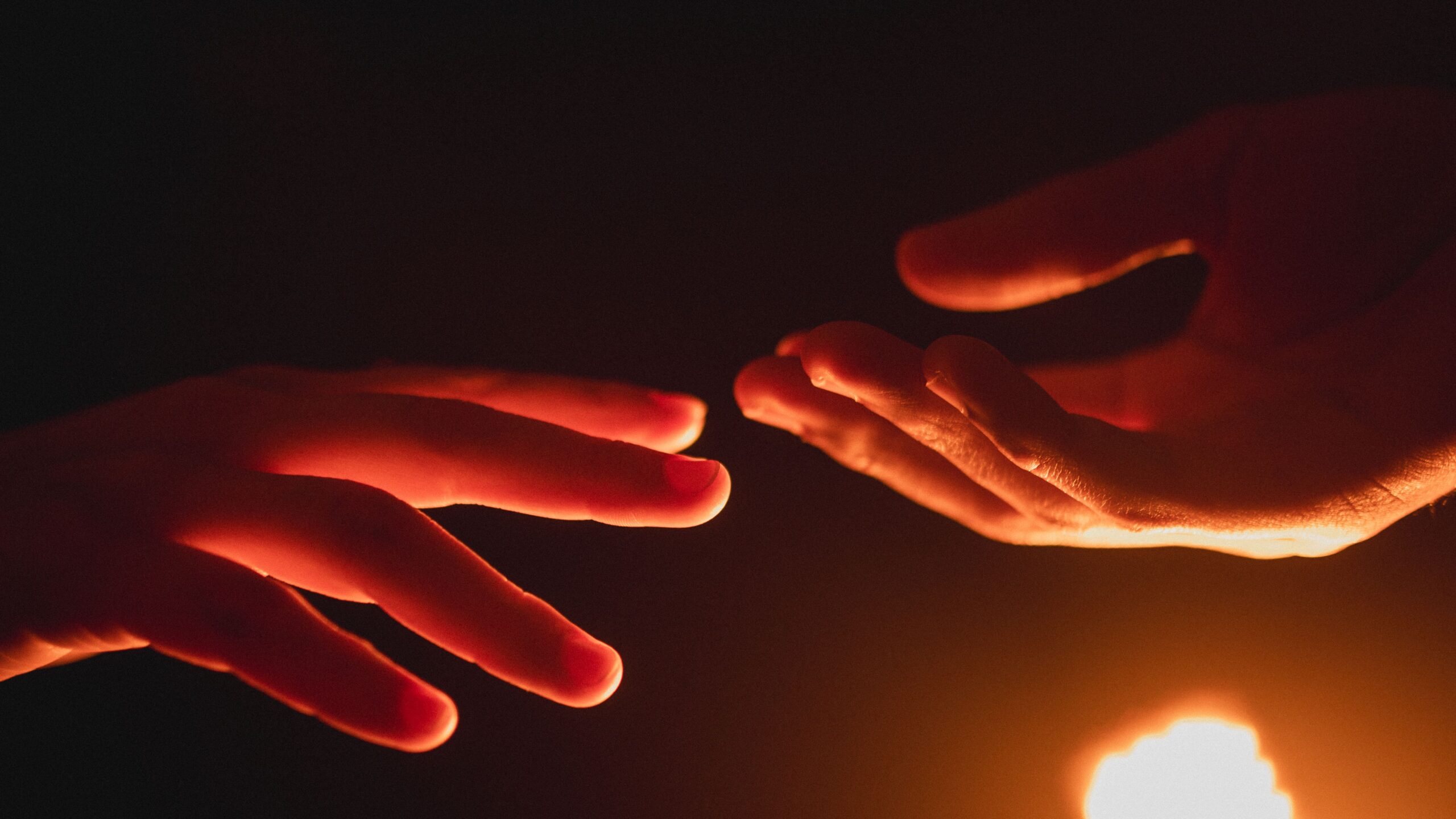 Mãos se tocando com luz quente e sombra